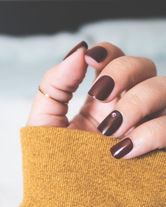 Les meilleurs faux ongle ! Une mains qui a des faux ongles marron de forme carré